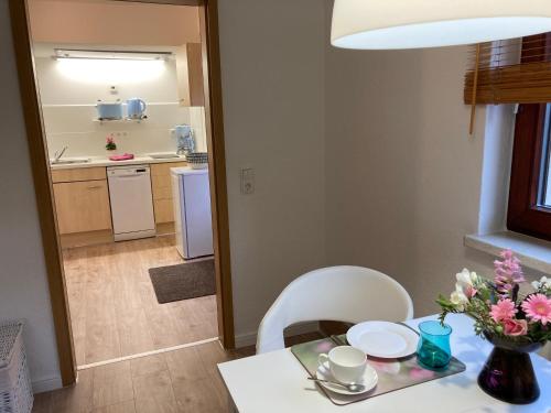 卑尔根Appartement 2 Garten的一张带白色椅子的餐桌和一间厨房