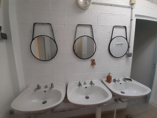 MoidreyGîte la Taniere Le jersey的浴室设有两个水槽和两面墙上的镜子