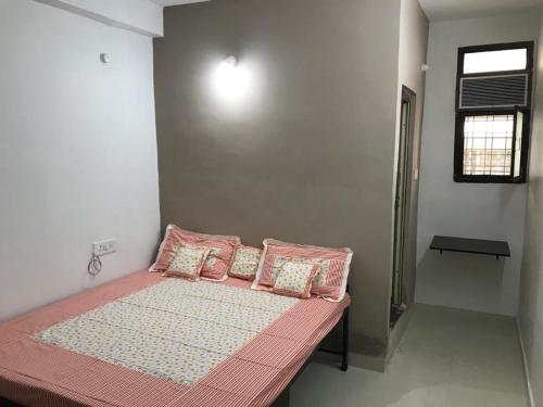 比拉斯布尔Prestige Guest House & Hostel的一间卧室配有一张带粉色床单和枕头的床。