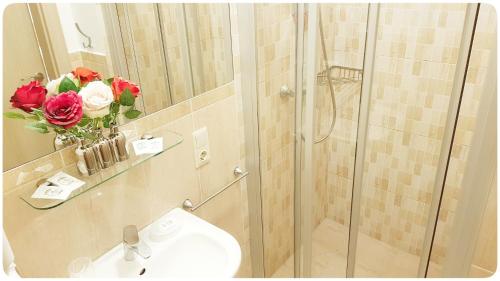 维尔纽斯Vivulskis Apart-Hotel的浴室配有盥洗盆和玫瑰淋浴