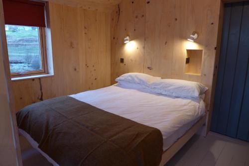 Port na LongThe Tin Church的卧室配有木墙内的一张床