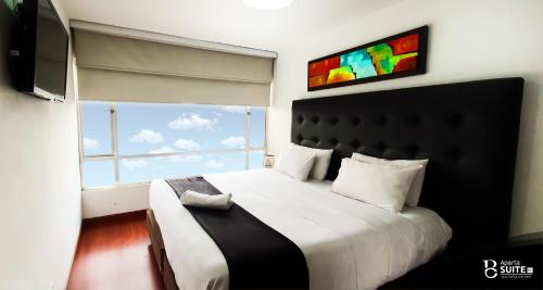 波哥大莫德利尔广场公寓式酒店的一间卧室设有一张大床和大窗户