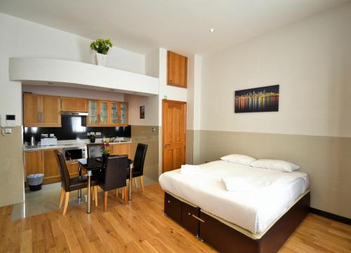伦敦海德公园公寓的一间卧室配有一张床铺和一张桌子,还设有一间厨房
