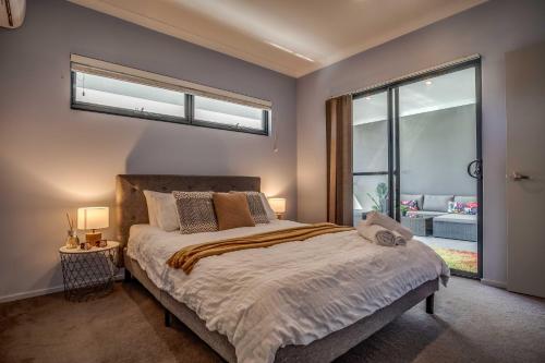 珀斯Maylands Boutique Apartments的一间卧室设有一张床和一个大窗户