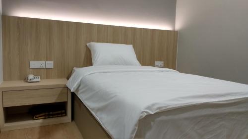 马六甲Maple Boutique Hotel的卧室配有一张白色的大床和床头柜。