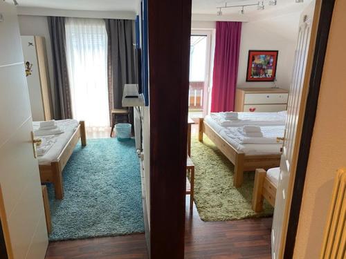 旧明斯特Hotel Wildschütz Basic的一间带两张床的卧室和一间带两张床的房间