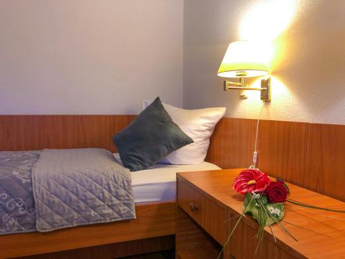 门兴格拉德巴赫Hotel Kaiser的一间卧室配有一张床和一张带台灯的桌子