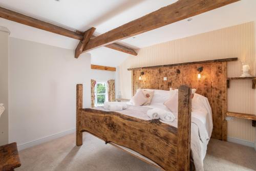 Rosedale AbbeyOrchard House的一间卧室配有一张带白色床单的木床
