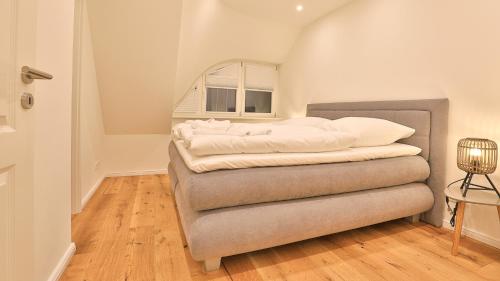 博恩Jade 4的一间卧室配有带白色枕头的床