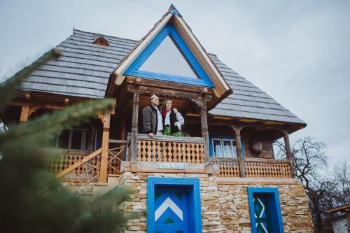 BrebCasa Moroșenilor - Breb的两人站在房子的阳台上