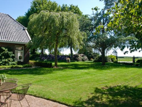 WittelteLandgoed Wittelte Dwingeloo的一个带桌椅的庭院和一棵树