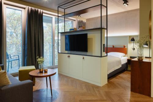 柏林Downtown Apartments Mitte-Wedding的一间卧室配有一张床,并在一间客房内配有电视。
