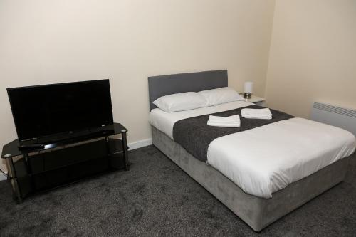 桑德兰AA Sunderland North的一间卧室配有一张床和一台平面电视