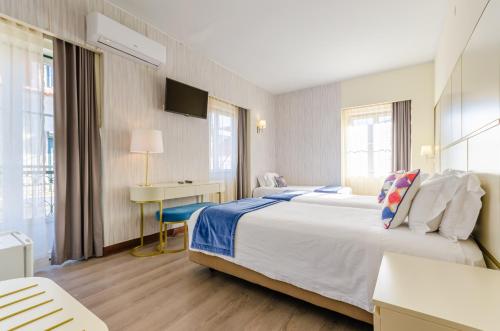 里斯本罗西奥LX酒店的酒店客房设有一张大床和一张书桌。