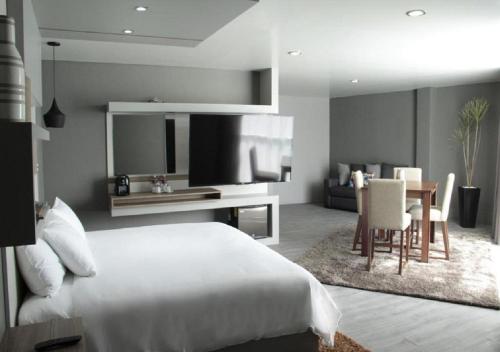 帕丘卡德索托ESDUMA HK HOTEL Pachuca的一间带白色床的卧室和一间用餐室