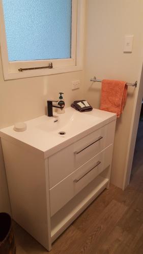莫拉基Jacks place的浴室设有白色水槽和镜子
