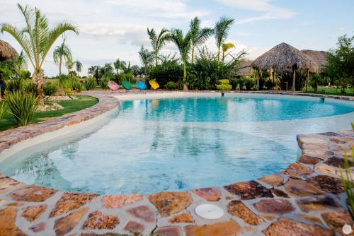 VillagránHotel y Villas Los Pirules by Rotamundos的棕榈树度假村内的游泳池
