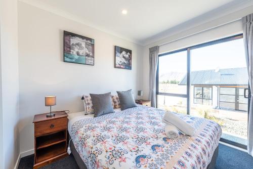 特卡波湖Matariki Star的一间卧室设有一张床和一个大窗户