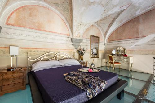 卢卡Villa Guinigi Dimora di Epoca Exclusive Residence & Pool的带天花板的客房内设有一张床的卧室