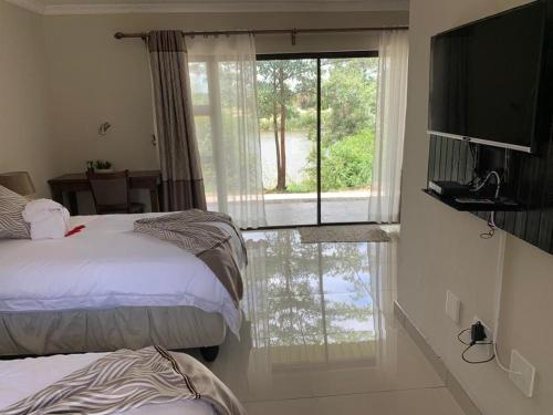 卡蒂马穆利洛Juda Haus Lodge的一间卧室设有两张床和大窗户