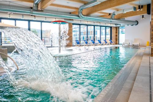 米兹多洛杰Bel Mare Resort的一座建筑物内一个带喷水装置的游泳池