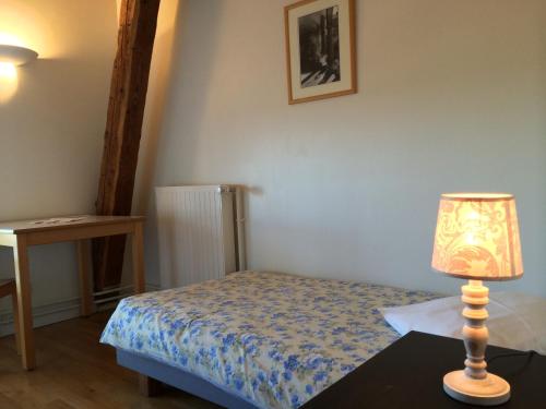 萨尔堡圣乌利奇修道院酒店的一间卧室配有一张床和一张桌子上的台灯