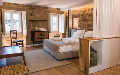 巴塞卢什Casa da Ana Boutique Guest House的卧室配有一张床和一张桌子及椅子