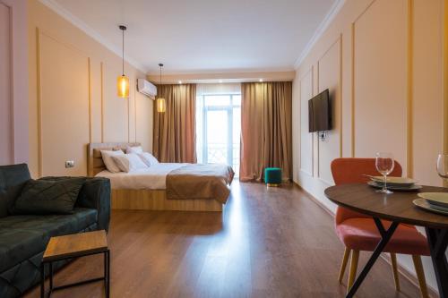 第比利斯Iren river side apartments的酒店客房配有床、沙发和桌子。