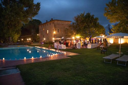 圣罗科阿费力Borgo San Lorenzo a Linari的一群人晚上站在游泳池周围