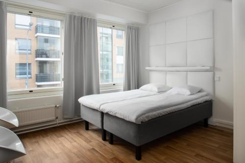 波里Omena Hotel Pori的白色的卧室设有床和窗户