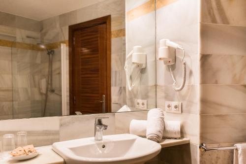 休达德亚Sagitario Hostal Ciutadella的一间带水槽和镜子的浴室