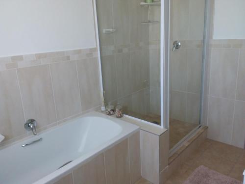 圣弗朗西斯湾Trev's Place的带淋浴和白色浴缸的浴室