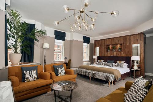 伯明翰伯明翰度微酒店的一间卧室配有一张床、两把椅子和一张沙发