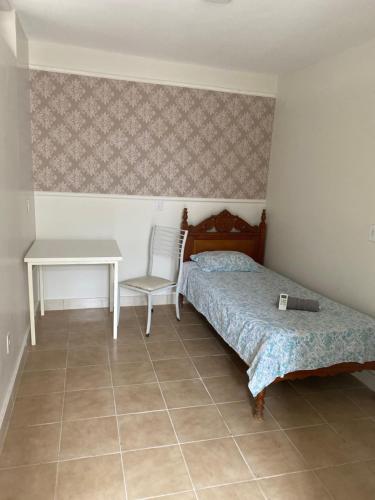 戈亚尼亚Hostel Pigally的一间卧室配有一张床、一张桌子和一张书桌