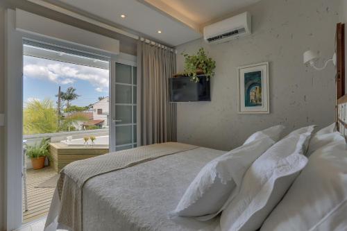 弗洛里亚诺波利斯Solar Beach Hotel的一间带大床的卧室和一个阳台