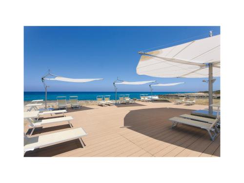 奥斯图尼玛赛丽亚圣塔卢西亚大酒店的海滩上的一组椅子和遮阳伞