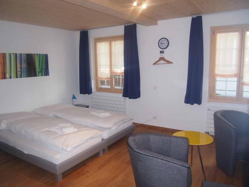 阿德尔博登Studio Zentrum EG的一间卧室配有一张床、一把椅子和蓝色窗帘