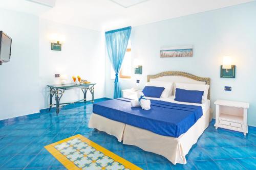 伊斯基亚麦格酒店的蓝色卧室,配有床和桌子