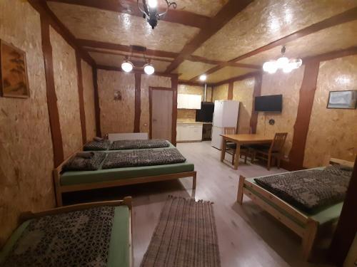 文茨皮尔斯布基娱乐露营地的带三张床和一张桌子的房间以及厨房