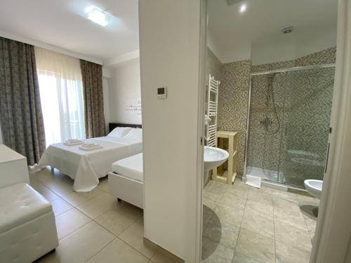 切萨雷奥港Palazzo Greco B&B的一间卧室配有一张床,浴室设有淋浴。