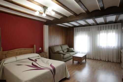 Matute de la SierraCasona Santa Coloma的一间卧室配有一张床和一张沙发