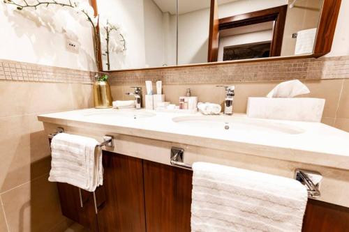 迪拜FIRST CLASS 3BR with full BURJ KHALIFA VIEW的浴室配有盥洗盆、镜子和毛巾