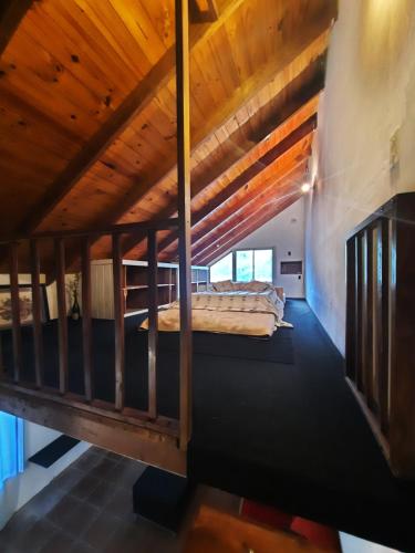 Don TorcuatoCabañas las palmeras的阁楼卧室设有床和木制天花板
