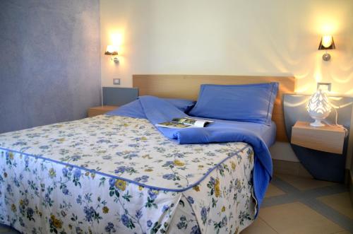 奥斯图尼马斯尔日亚艾斯纳酒店的一间卧室配有一张蓝色床单和一本书