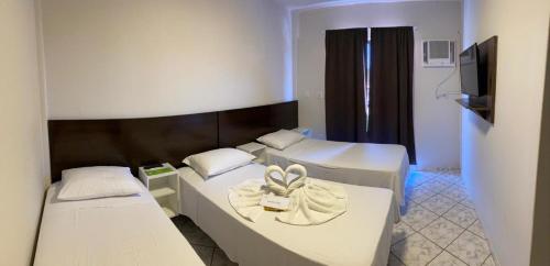 纳韦甘蒂斯Pousada Cores的酒店客房设有三张床和电视。
