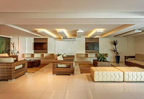 康德Tabatinga Flat - Beira Mar的一间大房间,位于一座建筑中,配有沙发和桌子