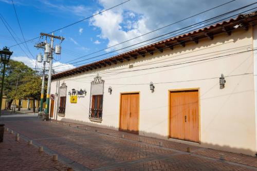科马亚瓜APARTAMENTOS CASCO HISTORICO COMAYAGUA的街道上带木门的白色建筑