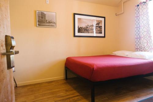 托诺帕Old Brewery Hostel的一间设有一张红色床罩的床的房间