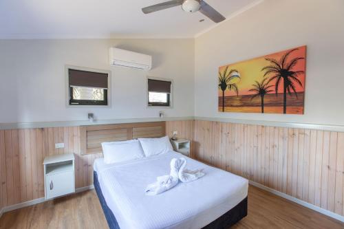 黄金海岸Main Beach Tourist Park的一间卧室配有一张带白色毛巾的床