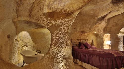 于尔居普黄金洞穴套房酒店的洞穴式卧室设有床和水槽